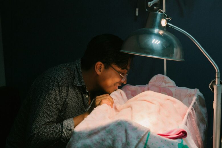 A father looking after his baby in a crib.