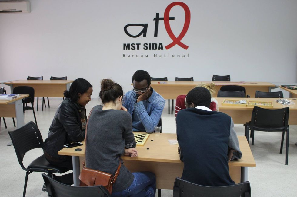 A group of young people play board games at an ATL MST SIDA facility in Tunisia.