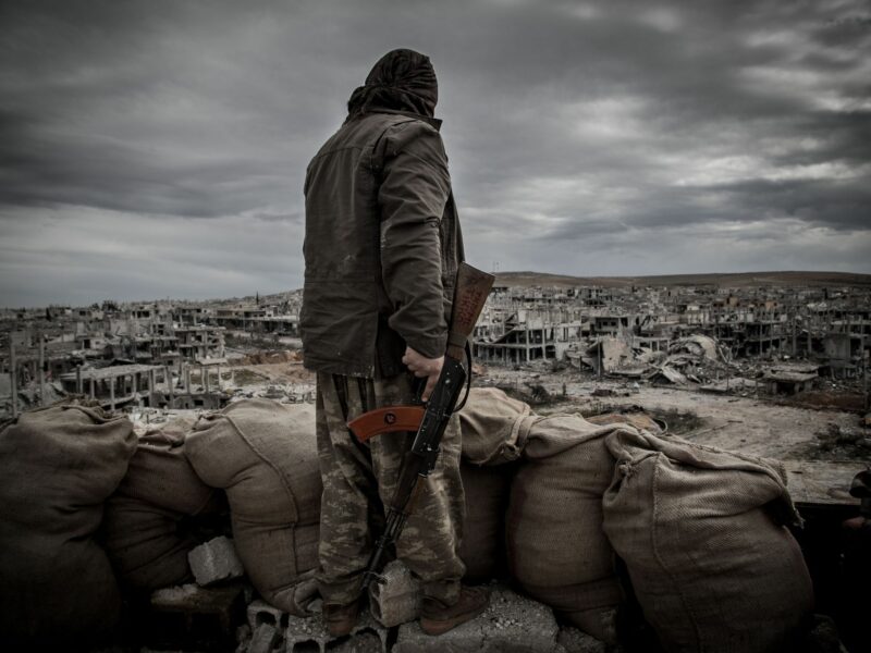 A Kurdish fighter walks through the wreckage of a building in the center of the Syrian town of Kobane