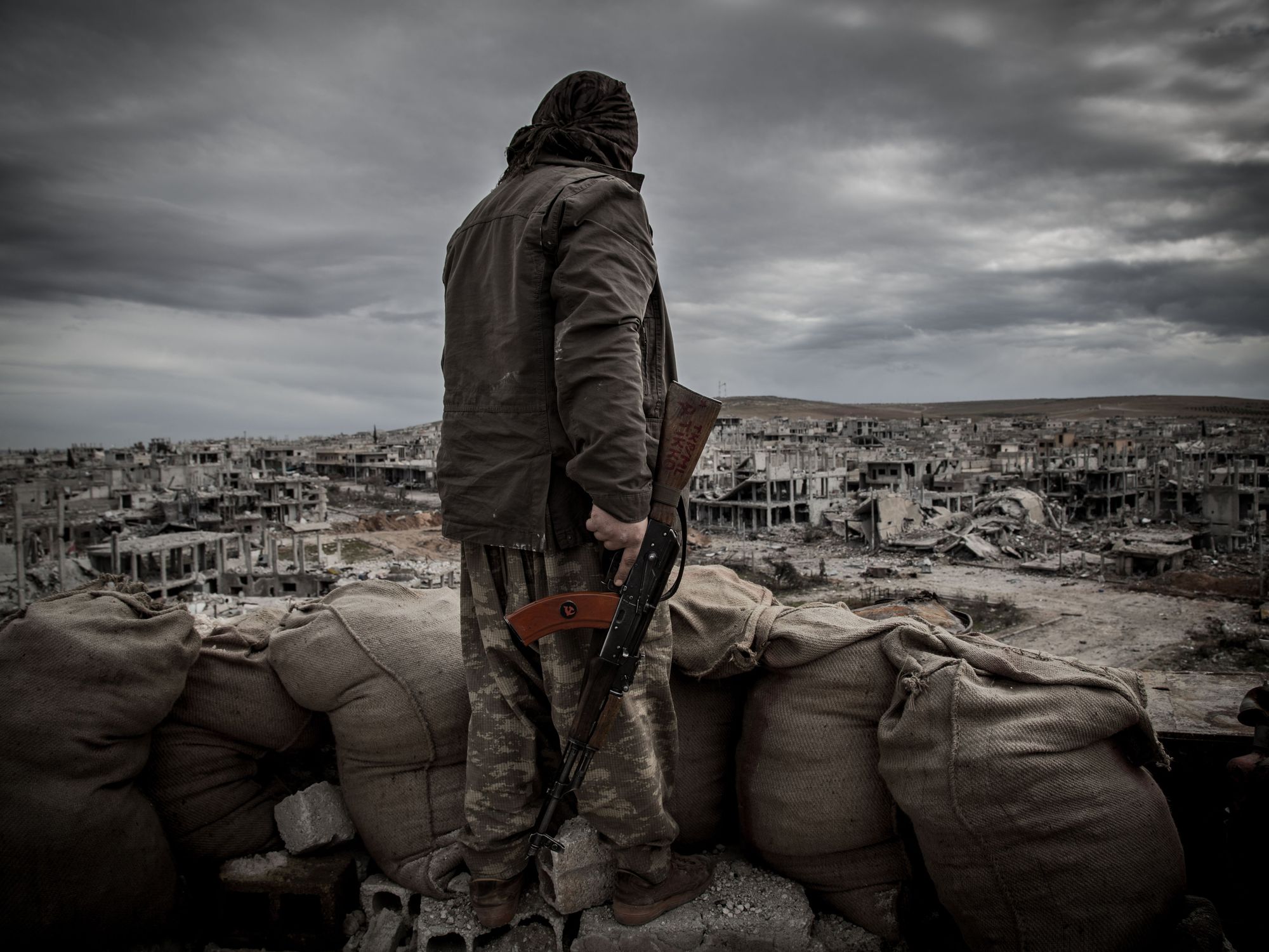 A Kurdish fighter walks through the wreckage of a building in the center of the Syrian town of Kobane