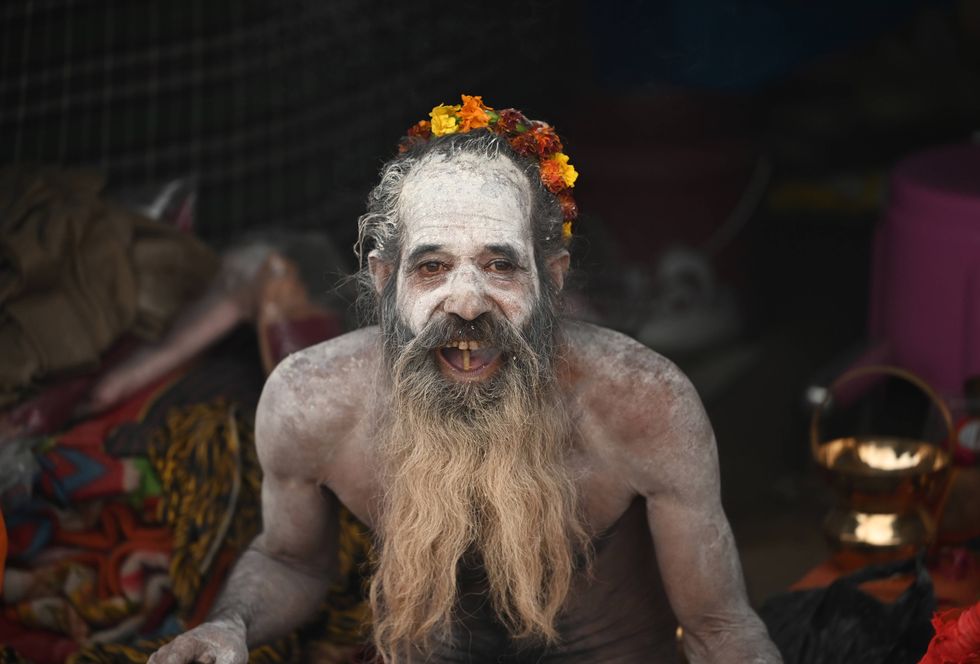 A Naga sadhu sits in his camp ahead of the festival