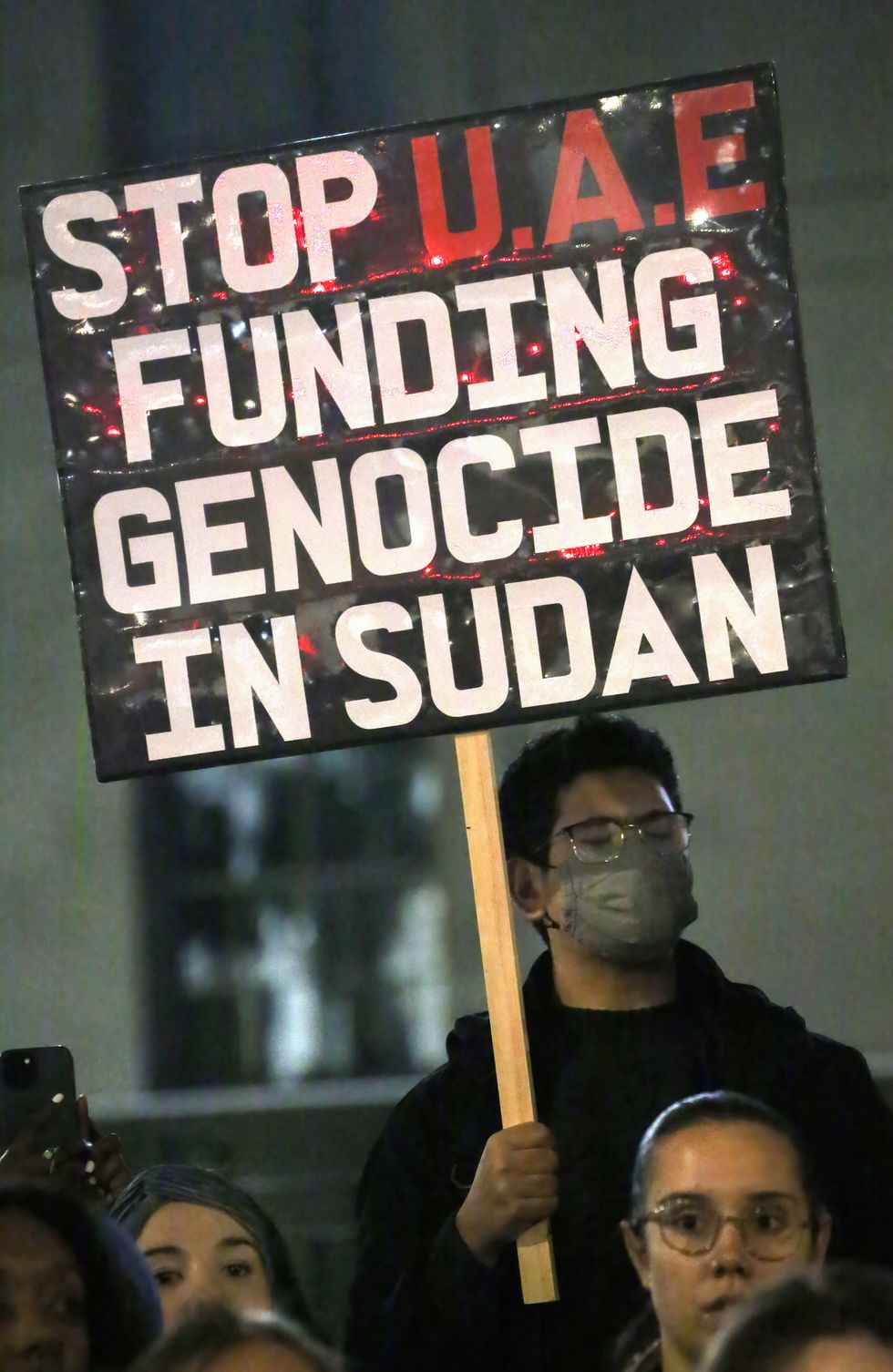 A protester holds a sign that reads 'Stop UAE Funding Genocide In Sudan' during the demonstration.
