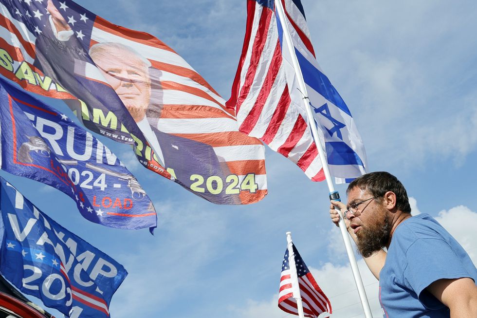 A Republican supporter holds a pole bearing the U.S. and the Israeli flags in June 2024, shortly after Trump invited Netanyahu over to his Mar-a-Lago estate.