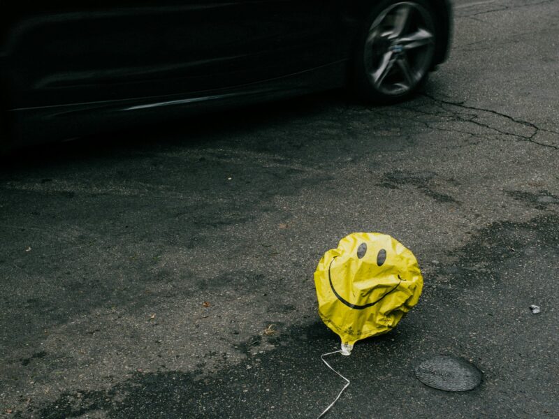 A smiling emoji balloon on the ground.