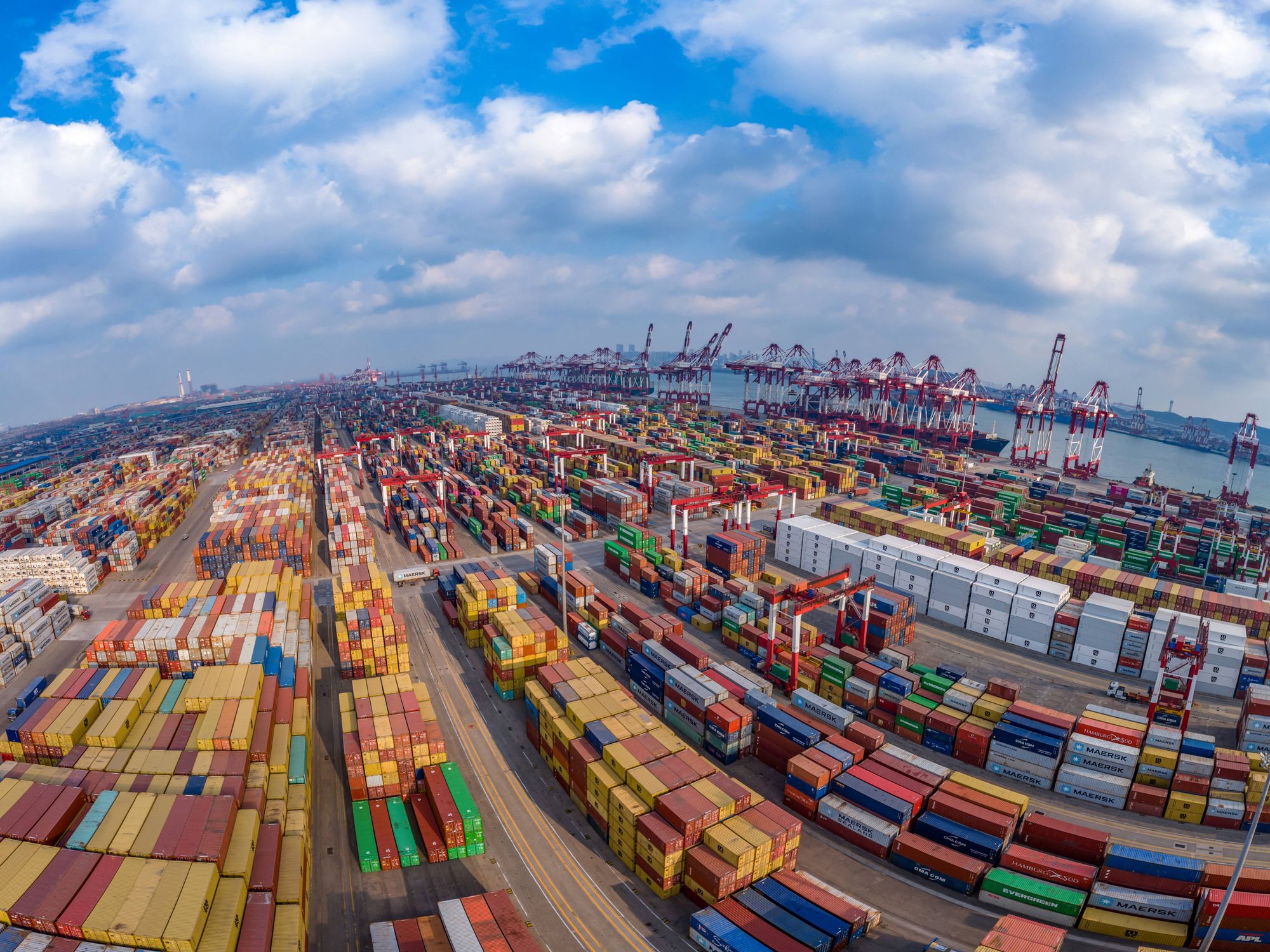 Aerial view of shipping containers sitting stacked at the Qianwan Container Terminal of Qingdao Port