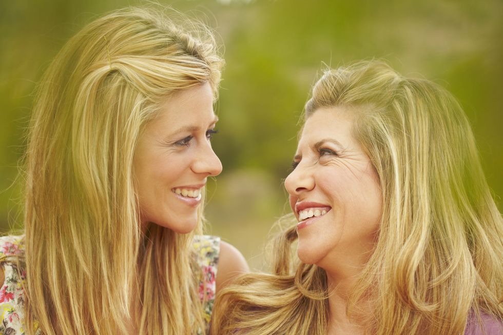 An adult woman looks at her mother as they both smile
