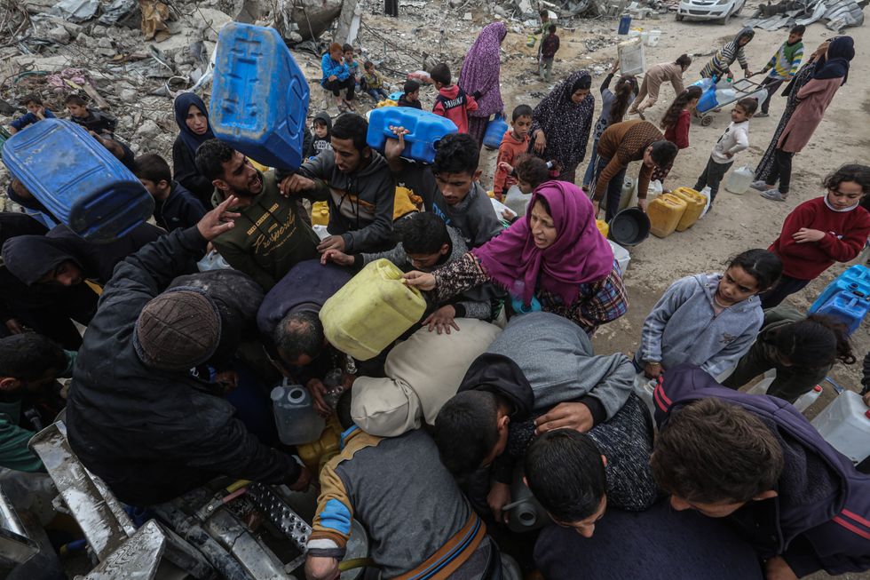 ​Palestinians try to collect water from a drinking water truck in the Jabalia refugee camp in Feb. 2025.