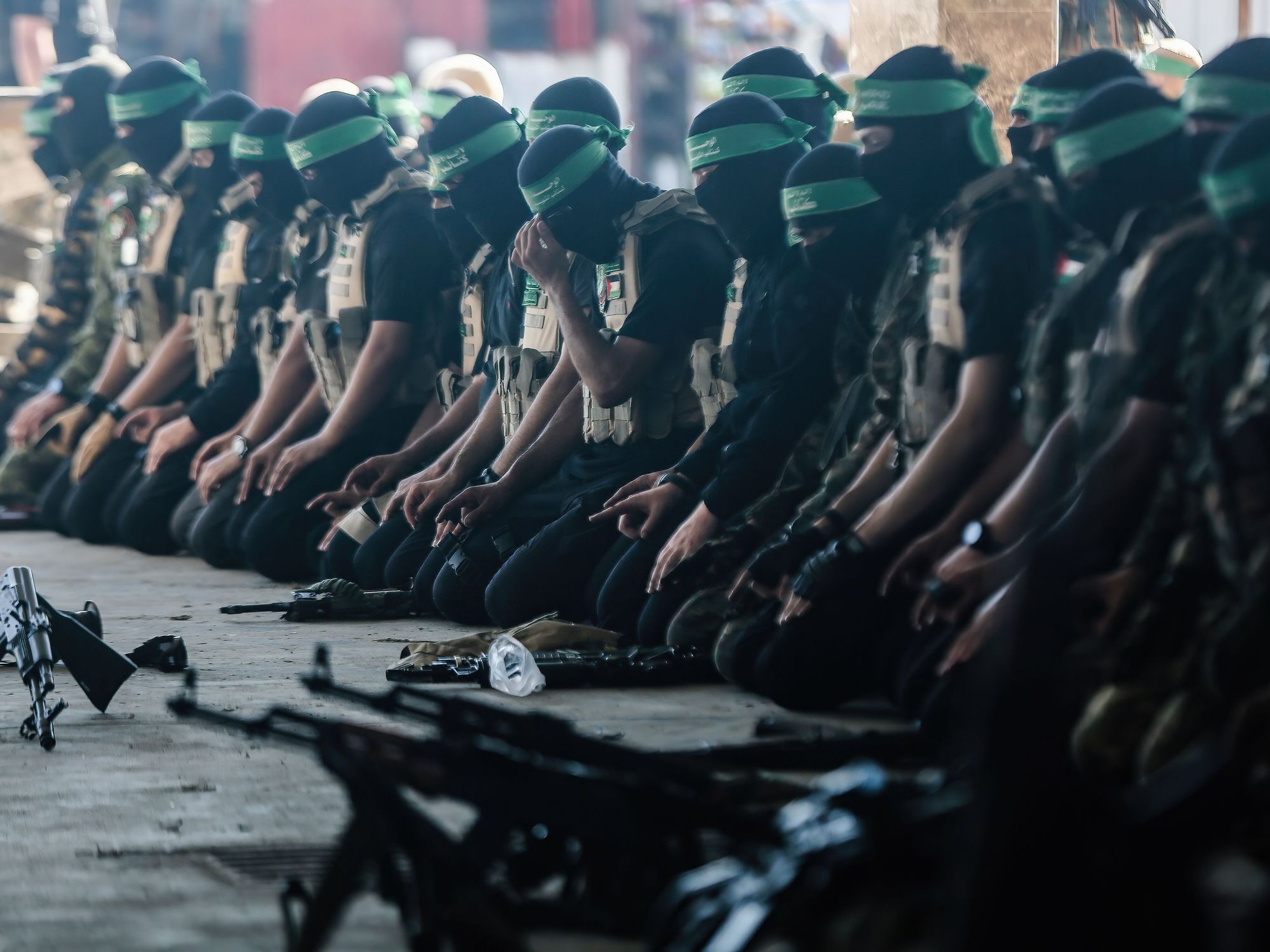 Hamas militia members kneeling in prayer.