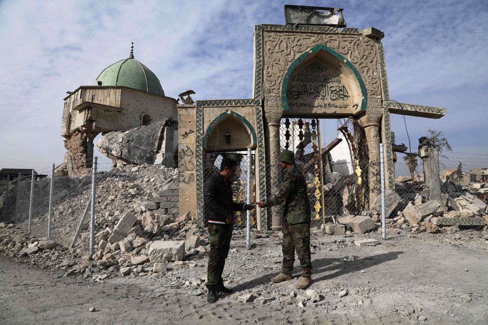 Iraqi soldiers talk outside the damaged al-Nuri mosque in the Old City of western Mosul.
