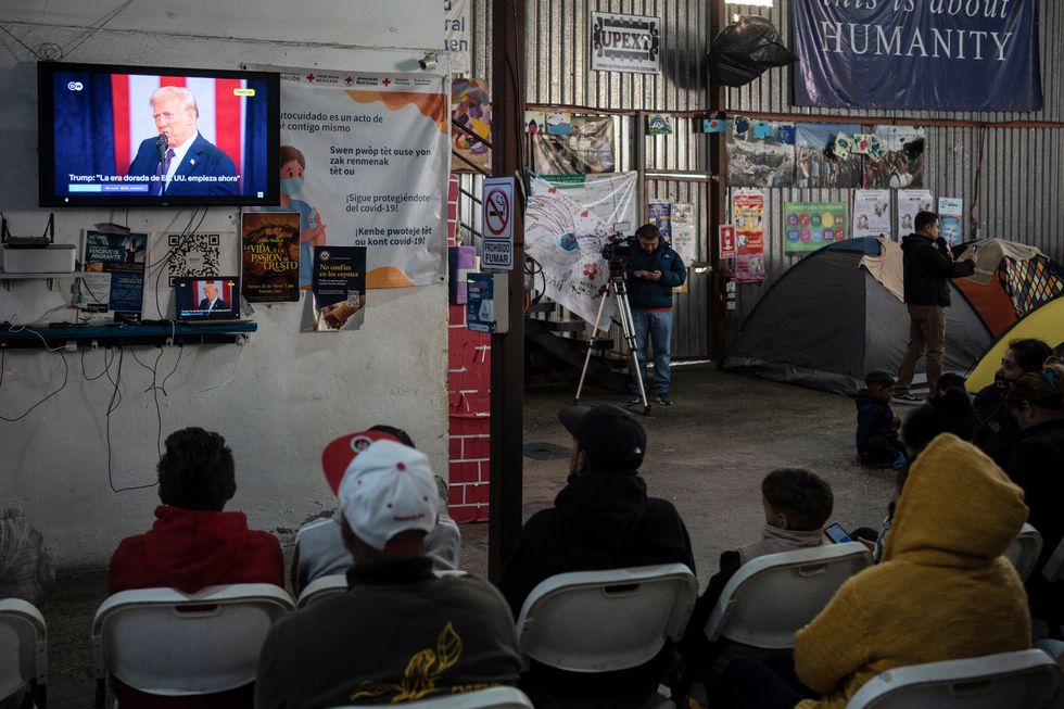 Latin American migrants watch the inauguration of US President Trump at the Juventud 2000 shelter in Tijuana, Mexico.