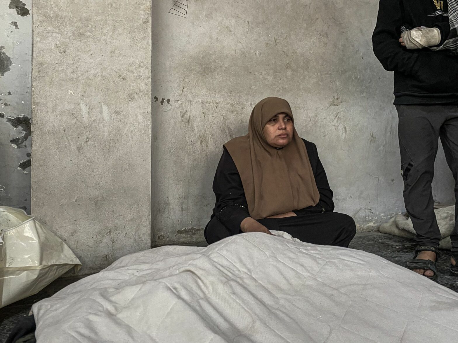 Mourners stand near the bodies of Palestinians killed in Israeli strikes