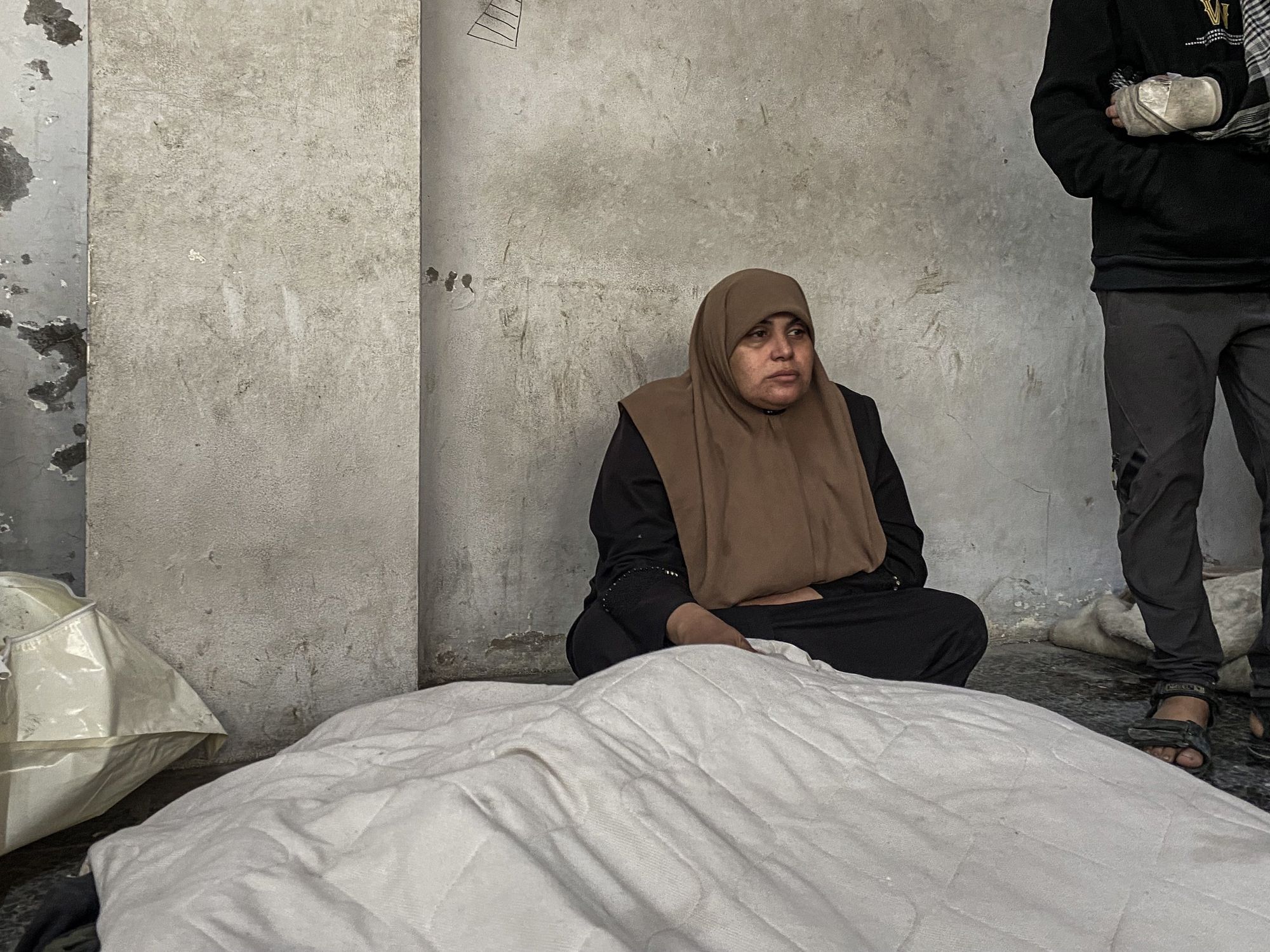 Mourners stand near the bodies of Palestinians killed in Israeli strikes