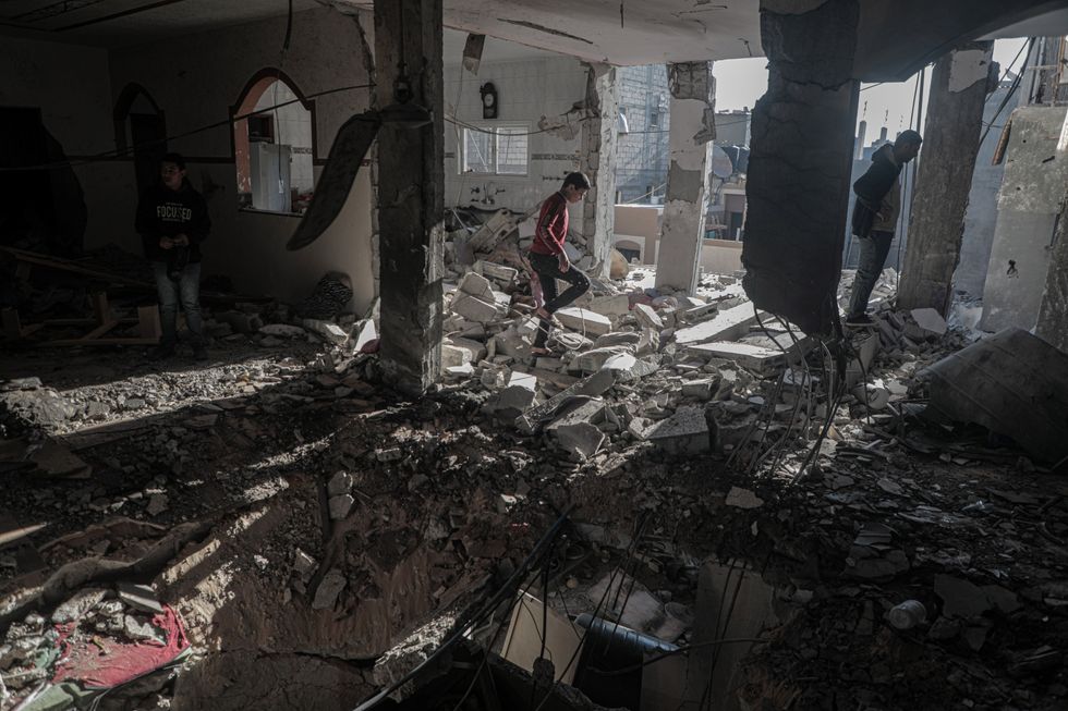 Palestinians at the site of a destroyed house after an Israeli bombardment, in Deir al-Balah refugee camp in the central Gaza Strip.