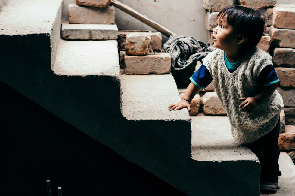Photo of a child climbing up stairs on his own