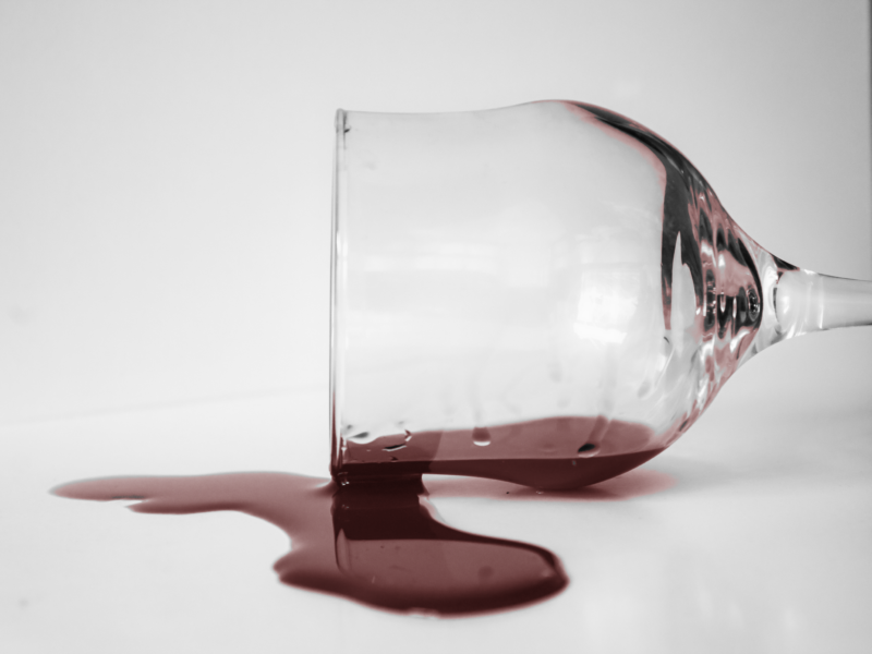 Photo of a glass of red wine spilled over
