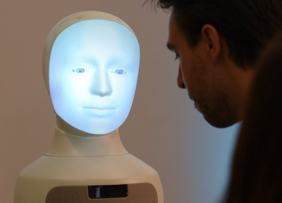 Photo of a humanoid robot next to a man