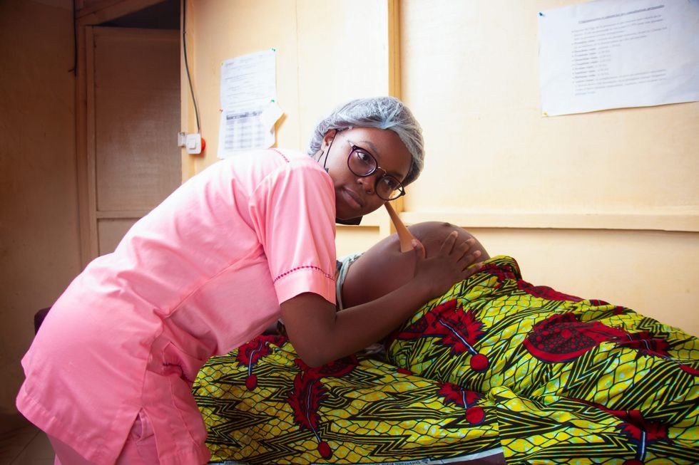 Photo of a male nurse examining a pregnant woman