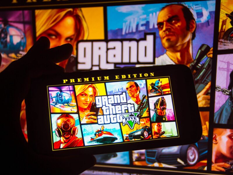 Photo of a person holding a phone with GTA visuals