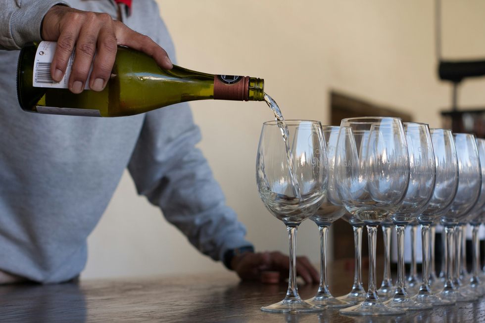 Photo of a person pouring white wine in glasses in Chile