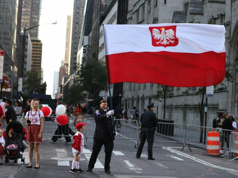 photo of a police officer holding a big polish flag