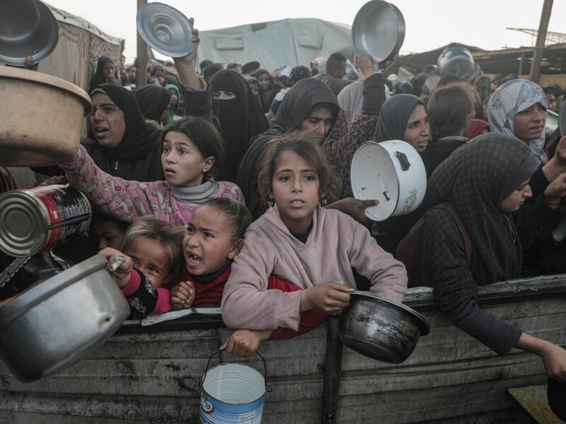 Photo of Palestinians waiting to get food from a charity kitchen.