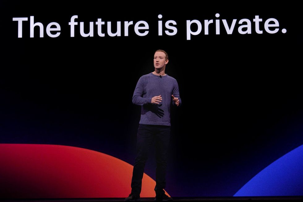 Photograph of ​Mark Zuckerberg giving a talk in a long-sleeved t-shirt and jeans.