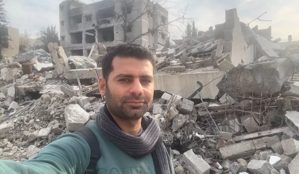 Salem Al-Rayyes pictured in front of rubble.