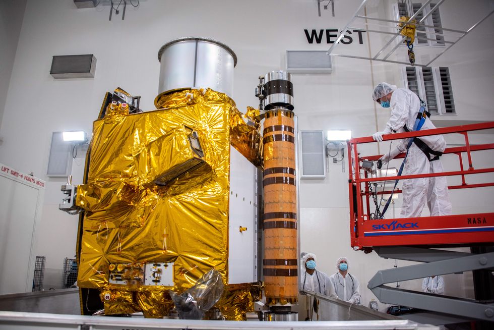 Technicians prepare to move NASA's Double Asteroid Redirection Test (DART) spacecraft onto a work stand inside the Astrotech Space Operations Facility at Vandenberg Space Force Base in California following its arrival at the facility on Oct. 4, 2021.