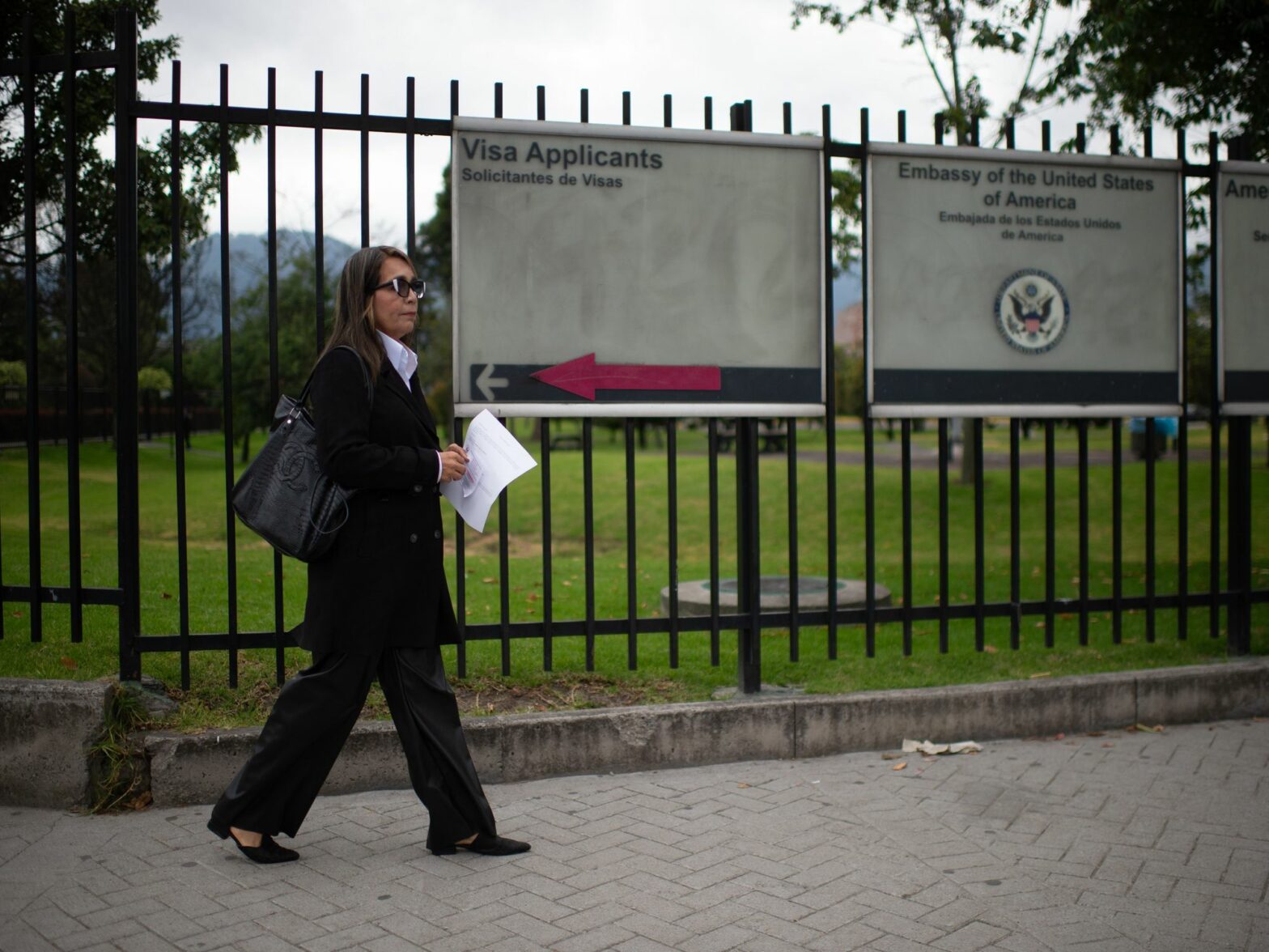 woman waiting outside US embassy in Bogota, Colombia.