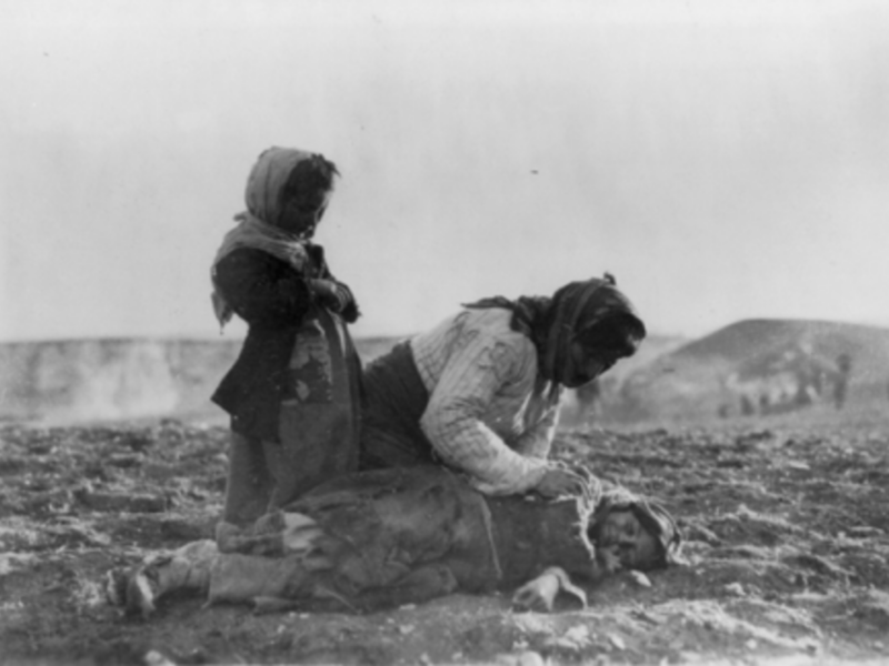 1915: Armenian woman kneeling beside dead child