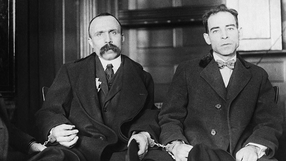 1923 black-and-white photo of ​Bartolomeo Vanzetti handcuffed to Nicola Sacco