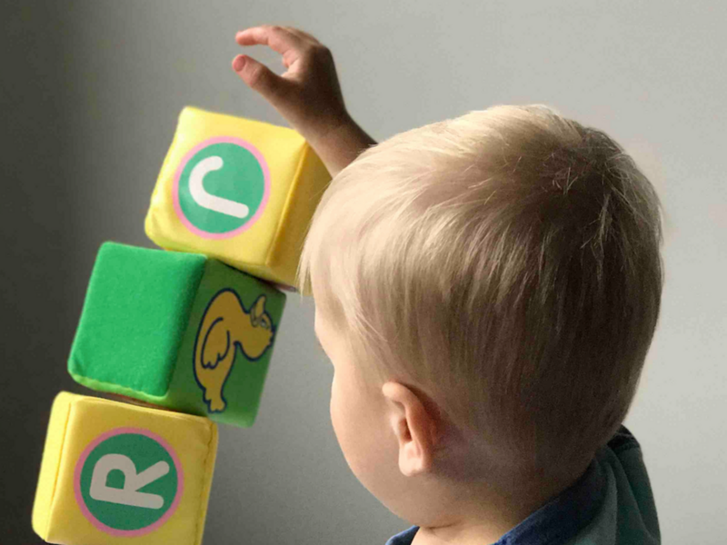 A baby builds stack of blocks​