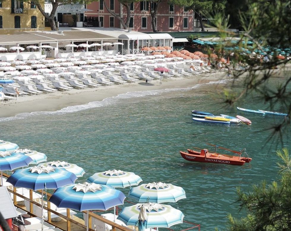 A beachfront full of empty chairs and parasols at Paraggi beach, Portofino, Italy.