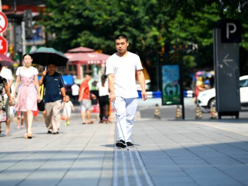 A blind person walks on the newly renovated 'blind sidewalk' in Chongqing, China