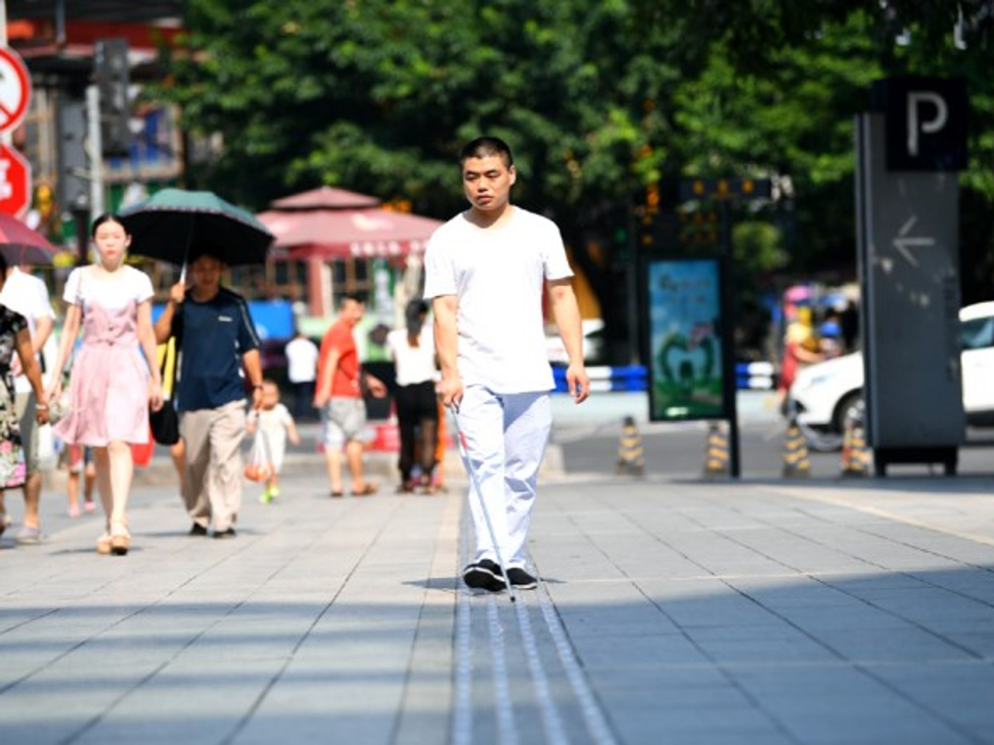 A blind person walks on the newly renovated 'blind sidewalk' in Chongqing, China