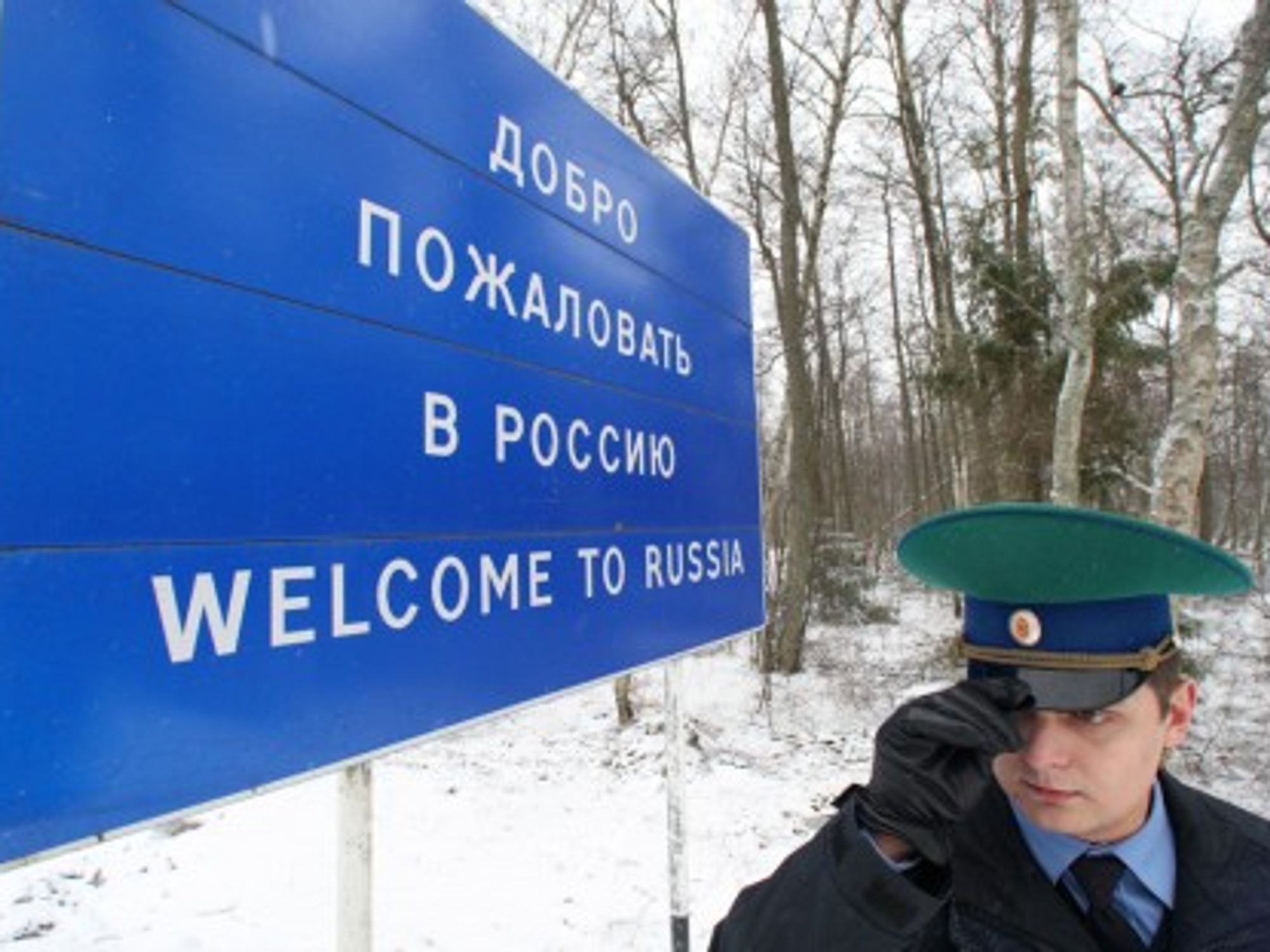A border guard at a "Welcome to Russia" sign
