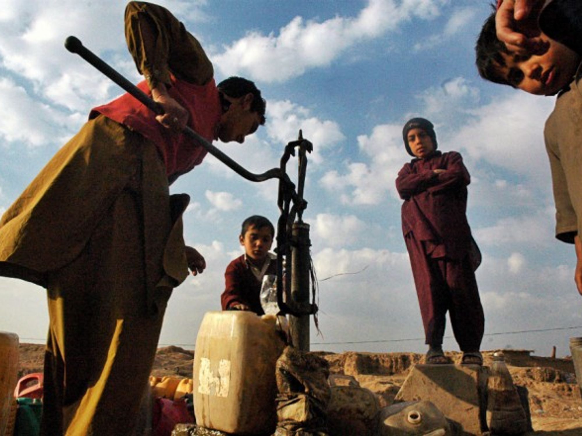 A boy filling water jugs on the outskirts of the capital of Pakistan