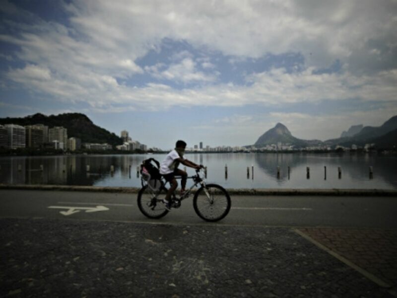 A boy peddles past the polluted Rodrigo de Freitas lagoon slated to be the site of sailing events at Rio 2016.