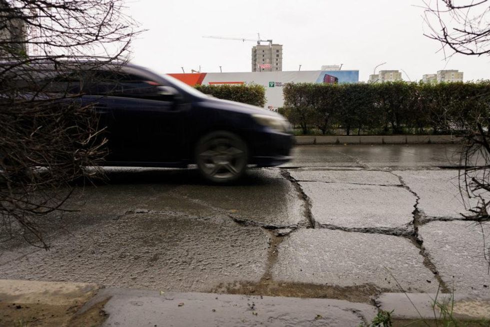 A car driving on a damaged road in Ulaanbaatar, Mongollia