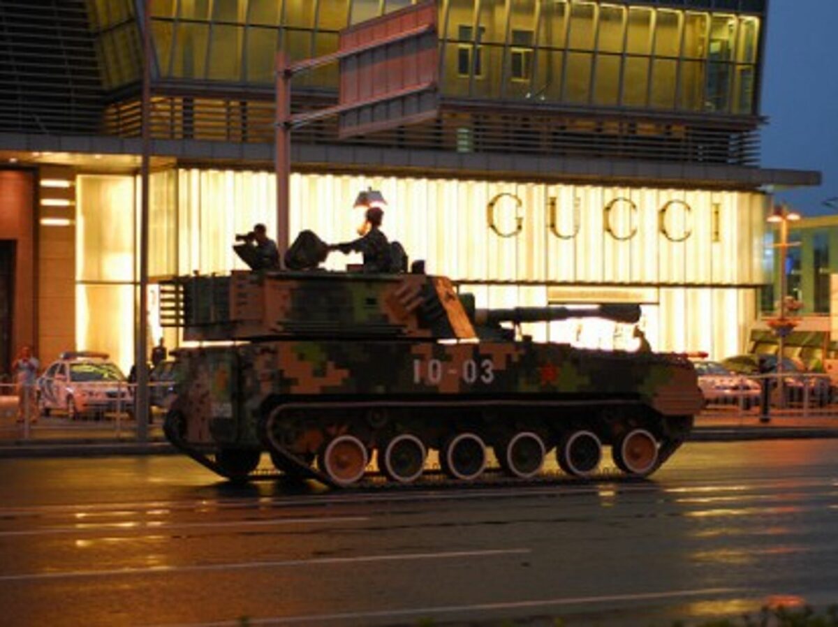 A Chinese tank rolls past a Gucci store in Beijing (gadgetdan)