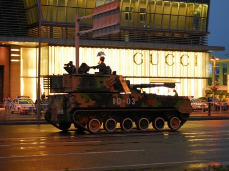 A Chinese tank rolls past a Gucci store in Beijing (gadgetdan)