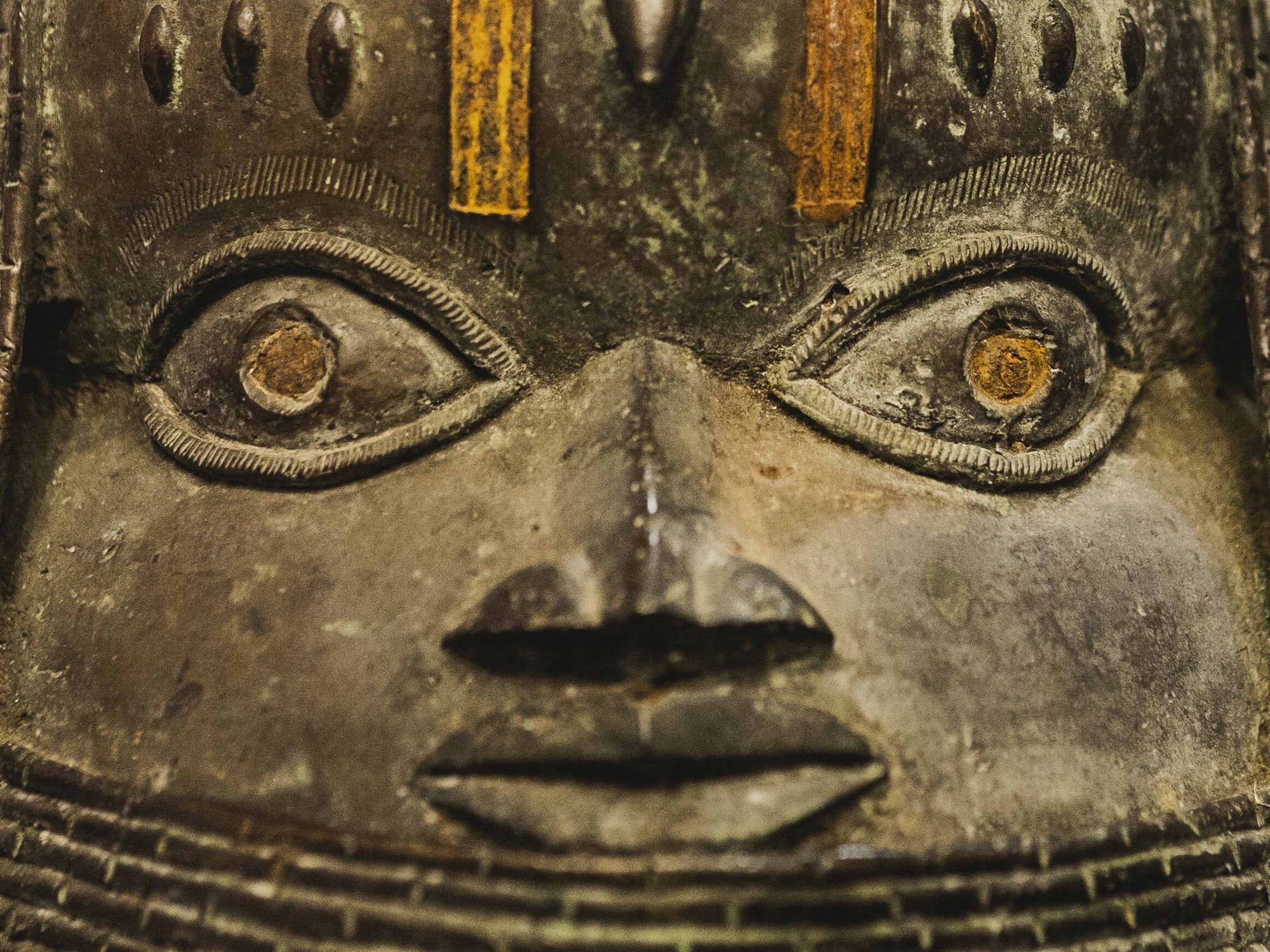 A close up of the face of a Benin bronze