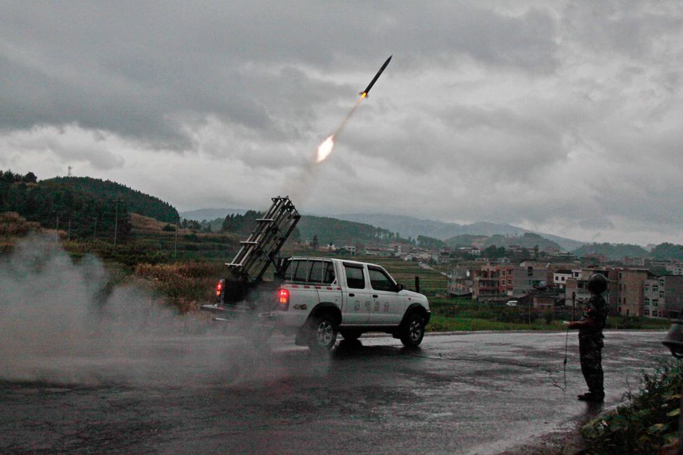 A cloud-seeding rocket blasts off from a launcher during a mission of artificial precipitation in China's Guizhou Province.