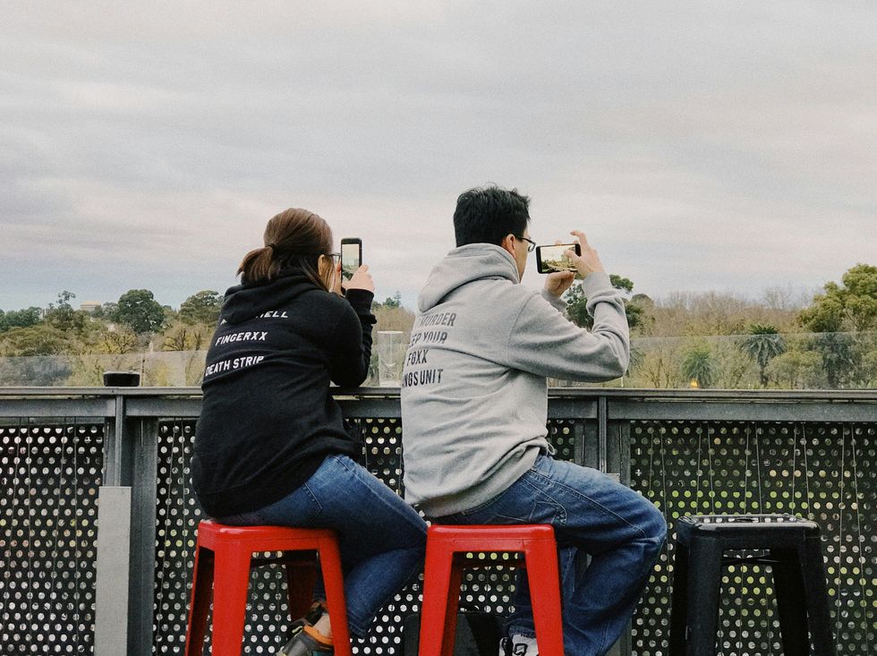 A couple takes a picture with their smartphones in Melbourne, Australia.