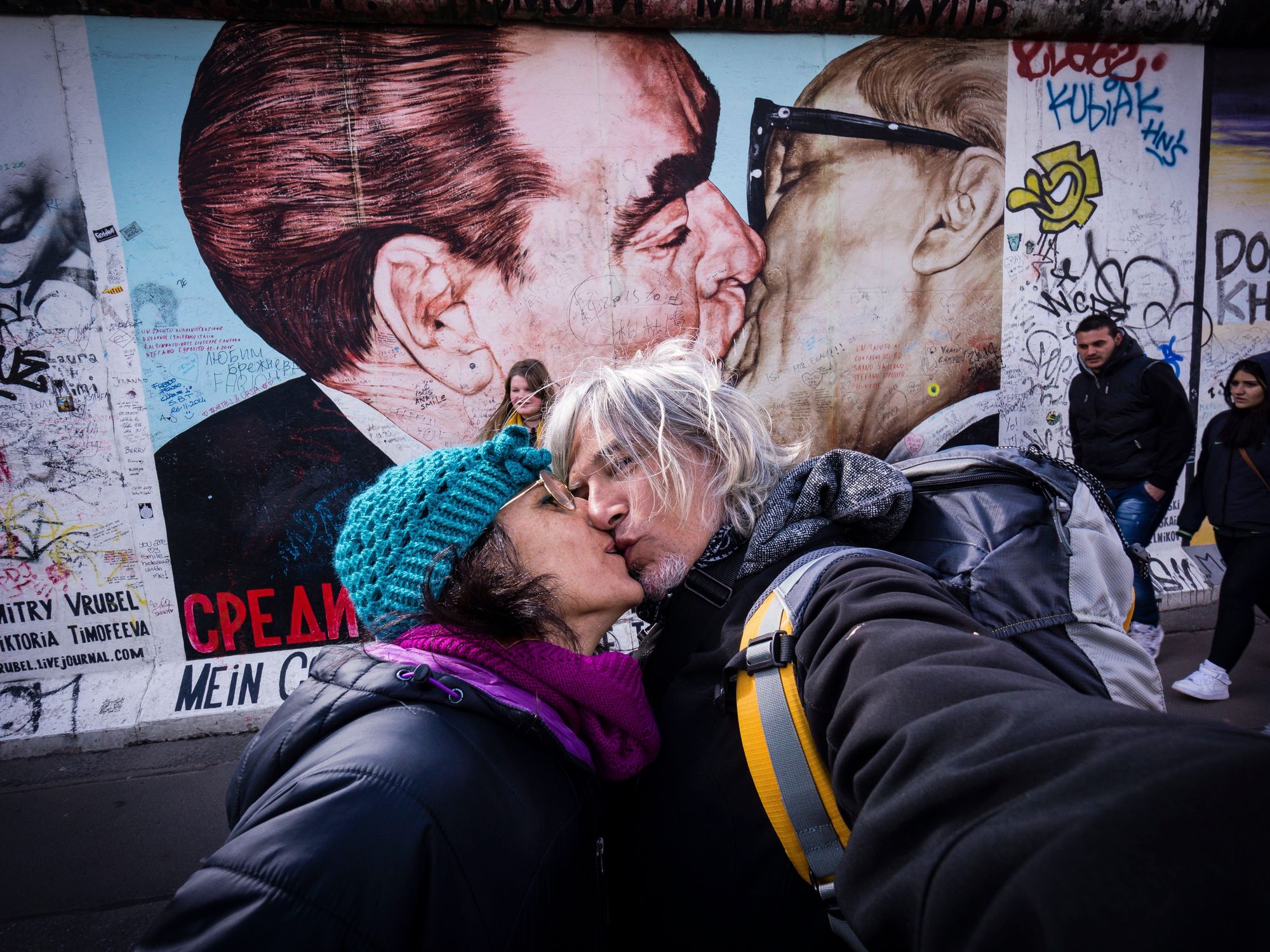 A couple takes a selfie in front of the "brotherly kiss" between USSR's leader Brezhnev and East Germany's president Honecker.