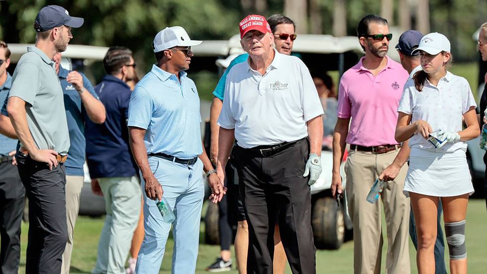 A crowd of people in golf clothes, including Majed Al Sorour and Donald Trump