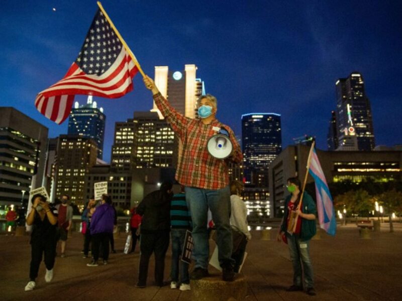 A Dallas voter waving an American Flag during a rally