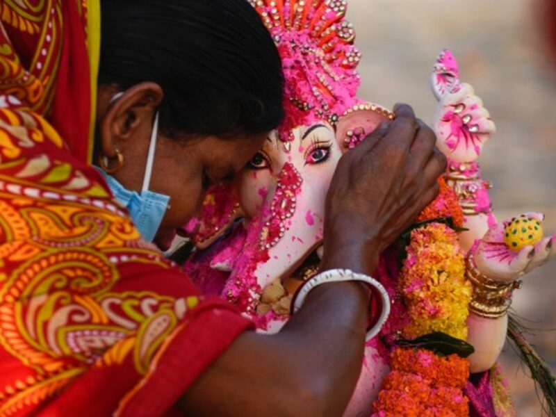 A devotee whispers a wish in the ear of an idol of Hindu deity Ganesha