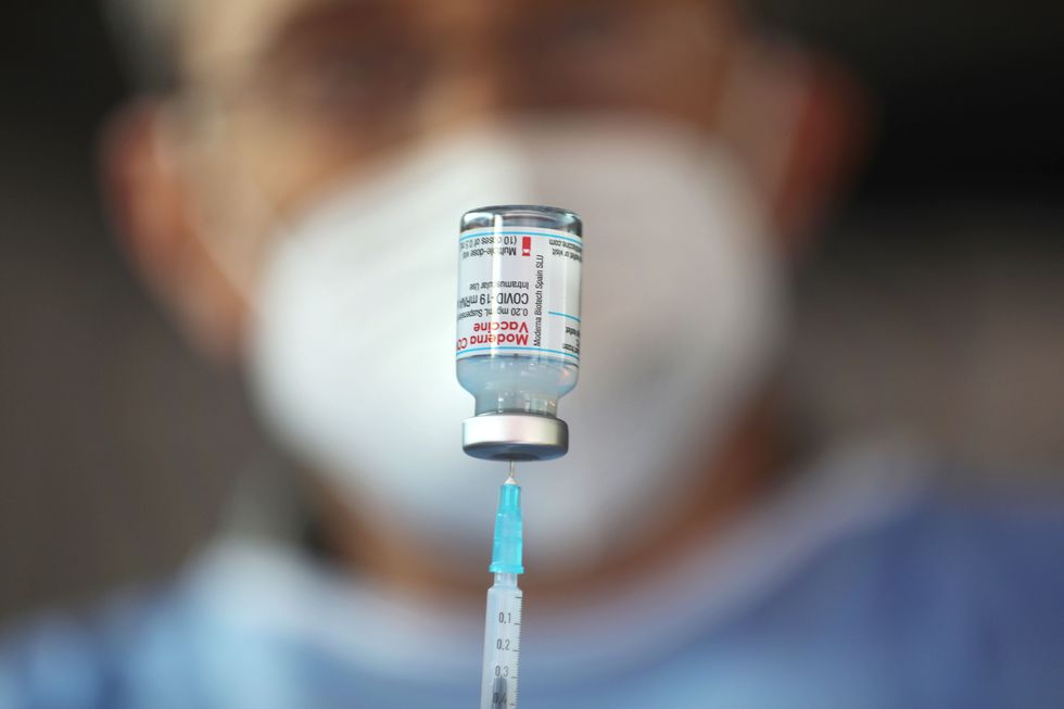 A doctor drawing up Moderna's Covid-19 vaccine in a syringe.