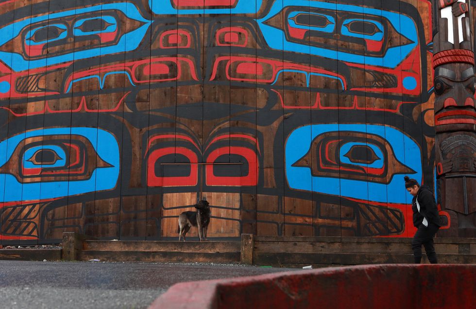A dog sits in front of the Big House in Bella Bella, B.C.